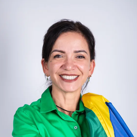 Alê Silva sorrindo com a bandeira do Brasil sobre o ombro